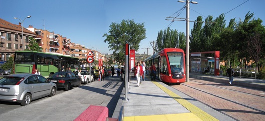 Intercity bus and light rail traveling on a road